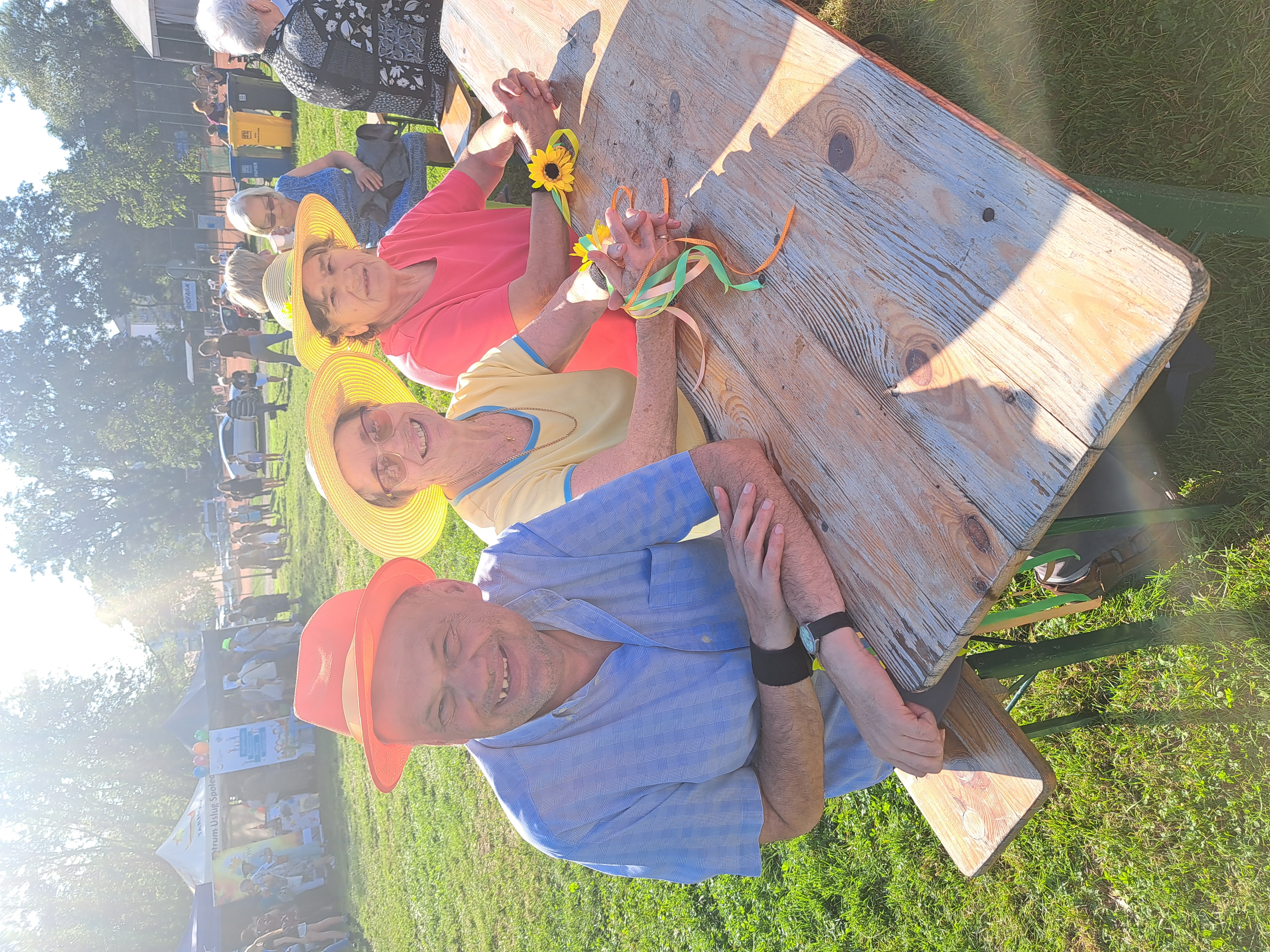 Troje Seniorów siedzi przy stoliku na błoniach tarnowskich