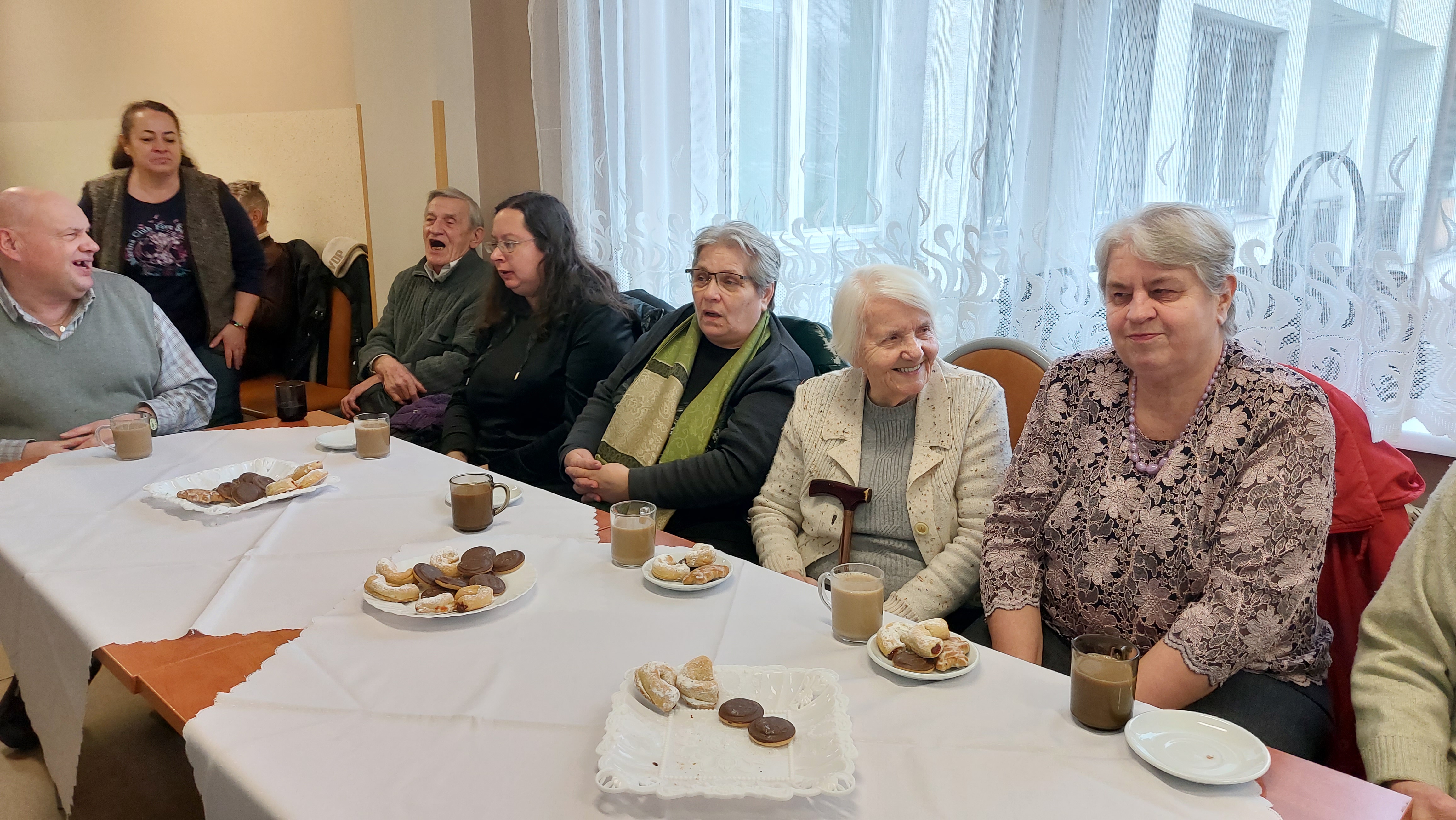 Grupowe zdjęcie Seniorów siedzących przy stole