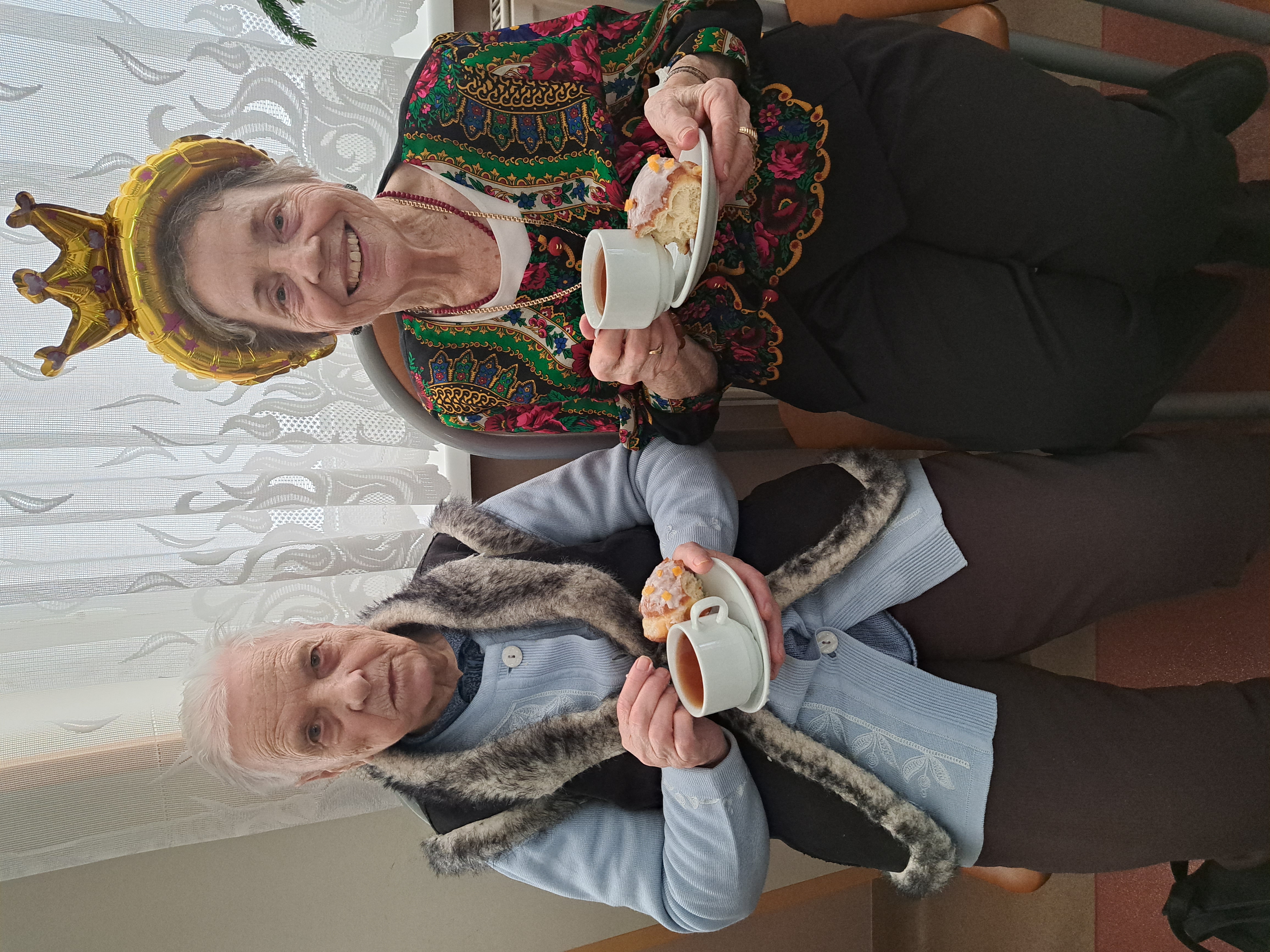 Dwie Seniorki pozują z kawą i ciasteczkiem