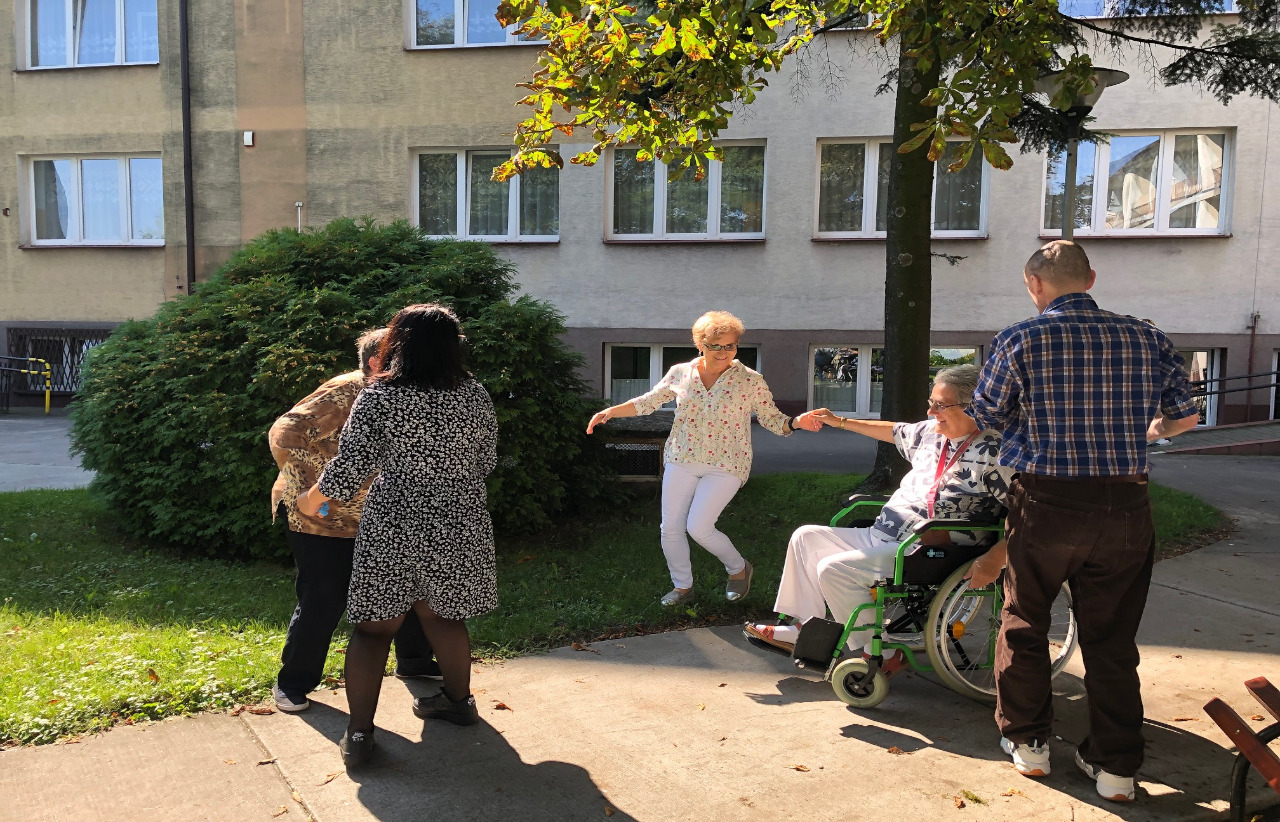 Seniorzy tańczą w ogrodzie