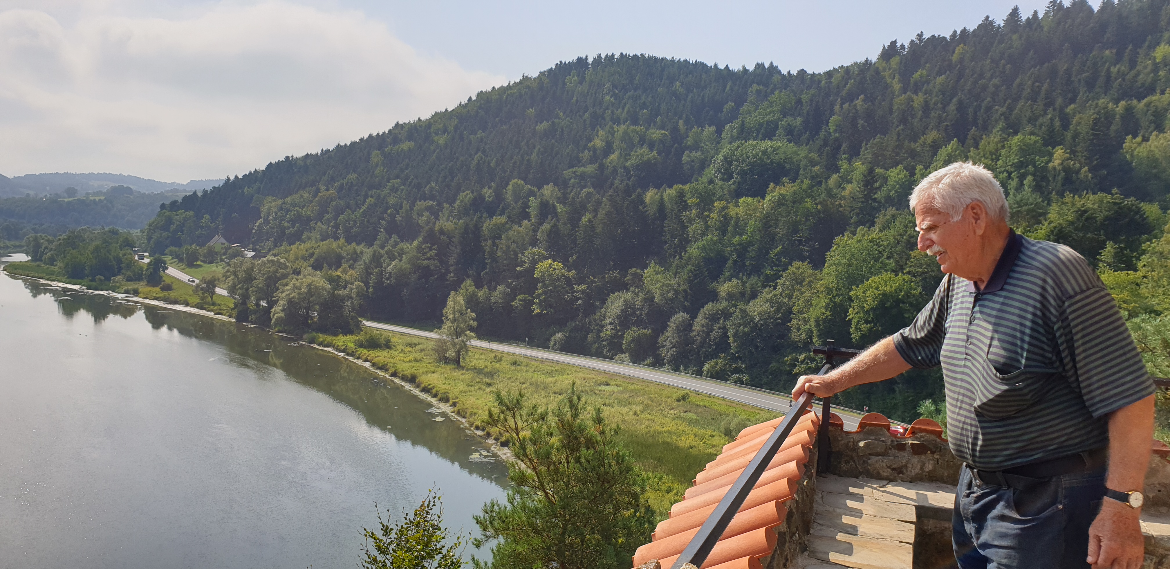 Senior na wieżyczce zamku, w tle widok na jezioro