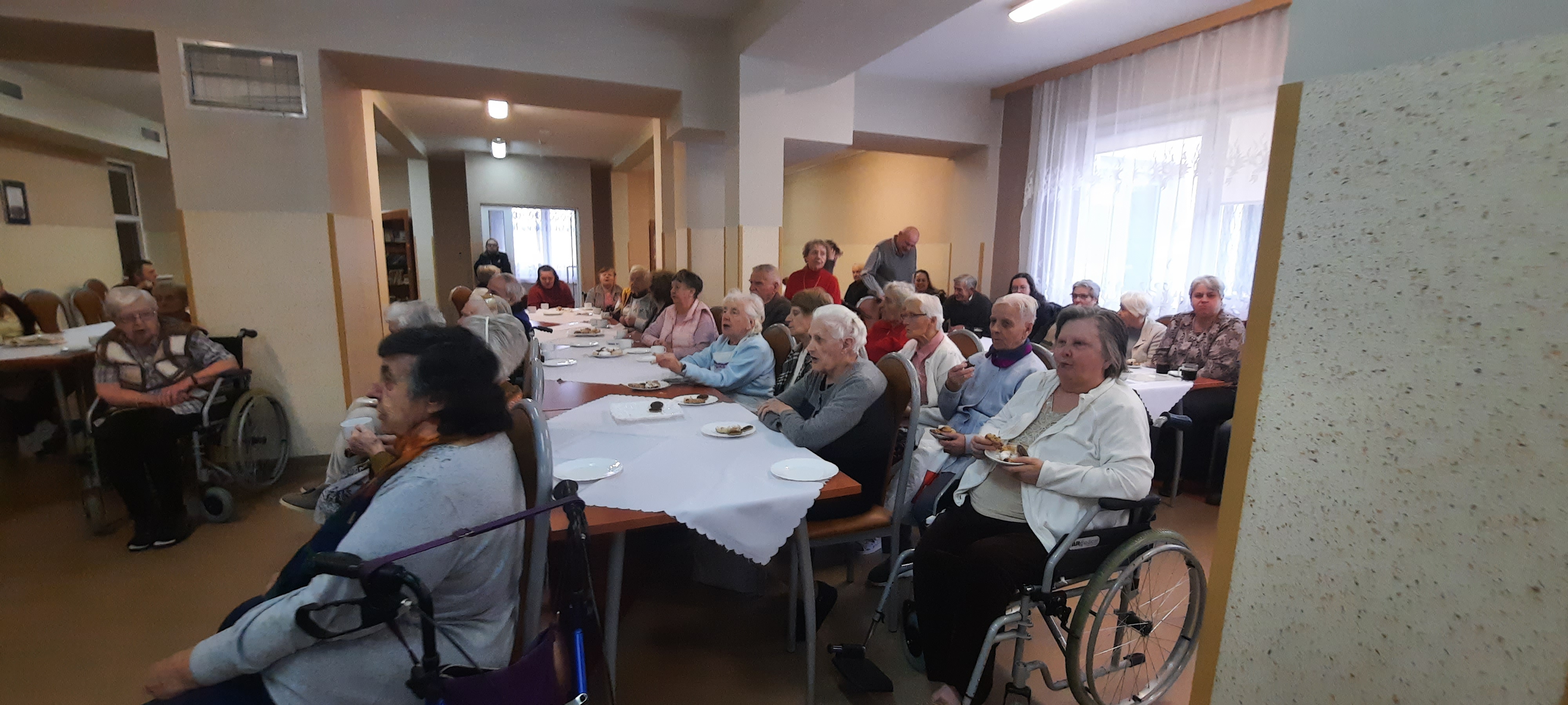 Grupowe zdjęcie Seniorów, siedzących na świetlicy