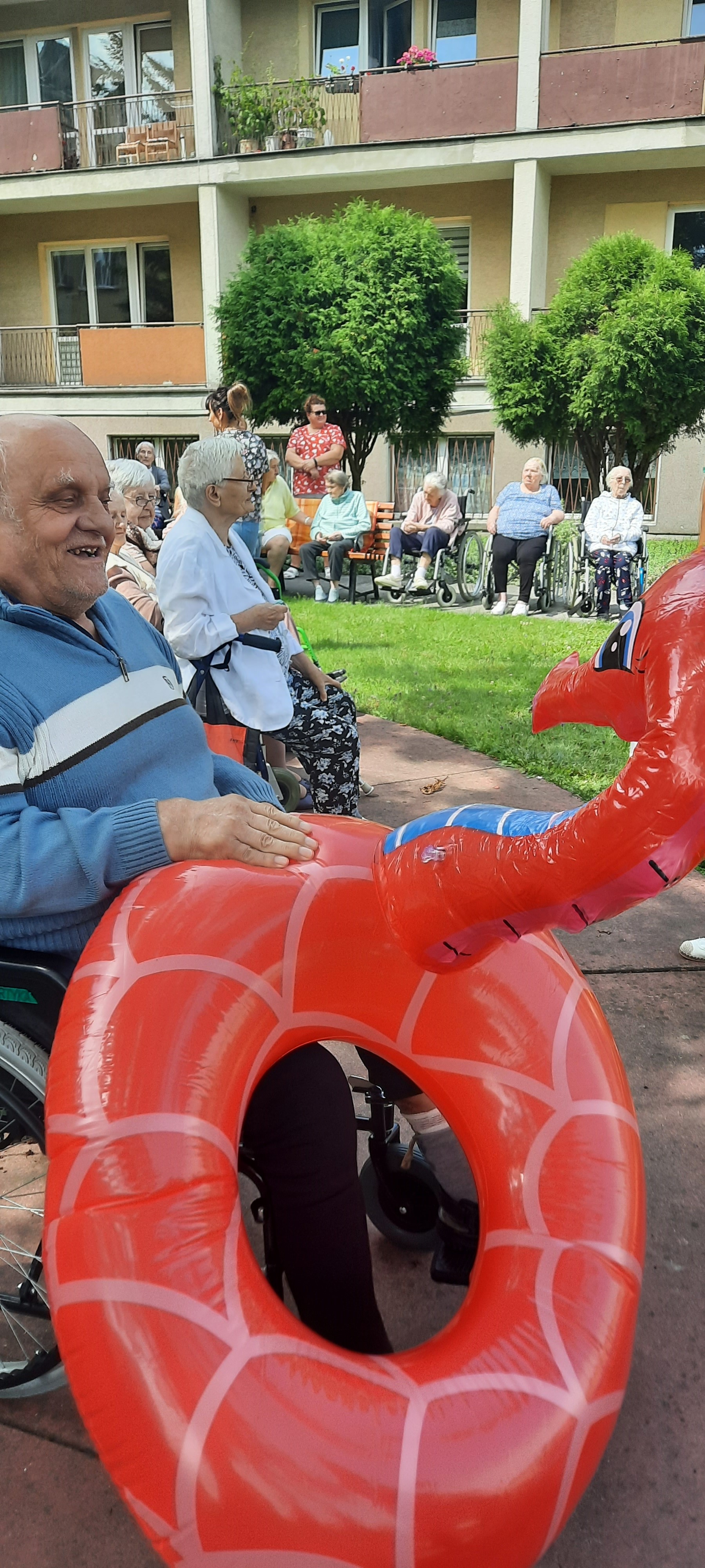 Senior trzyma w ręce kółko pływackie w kształcie konika morskiego