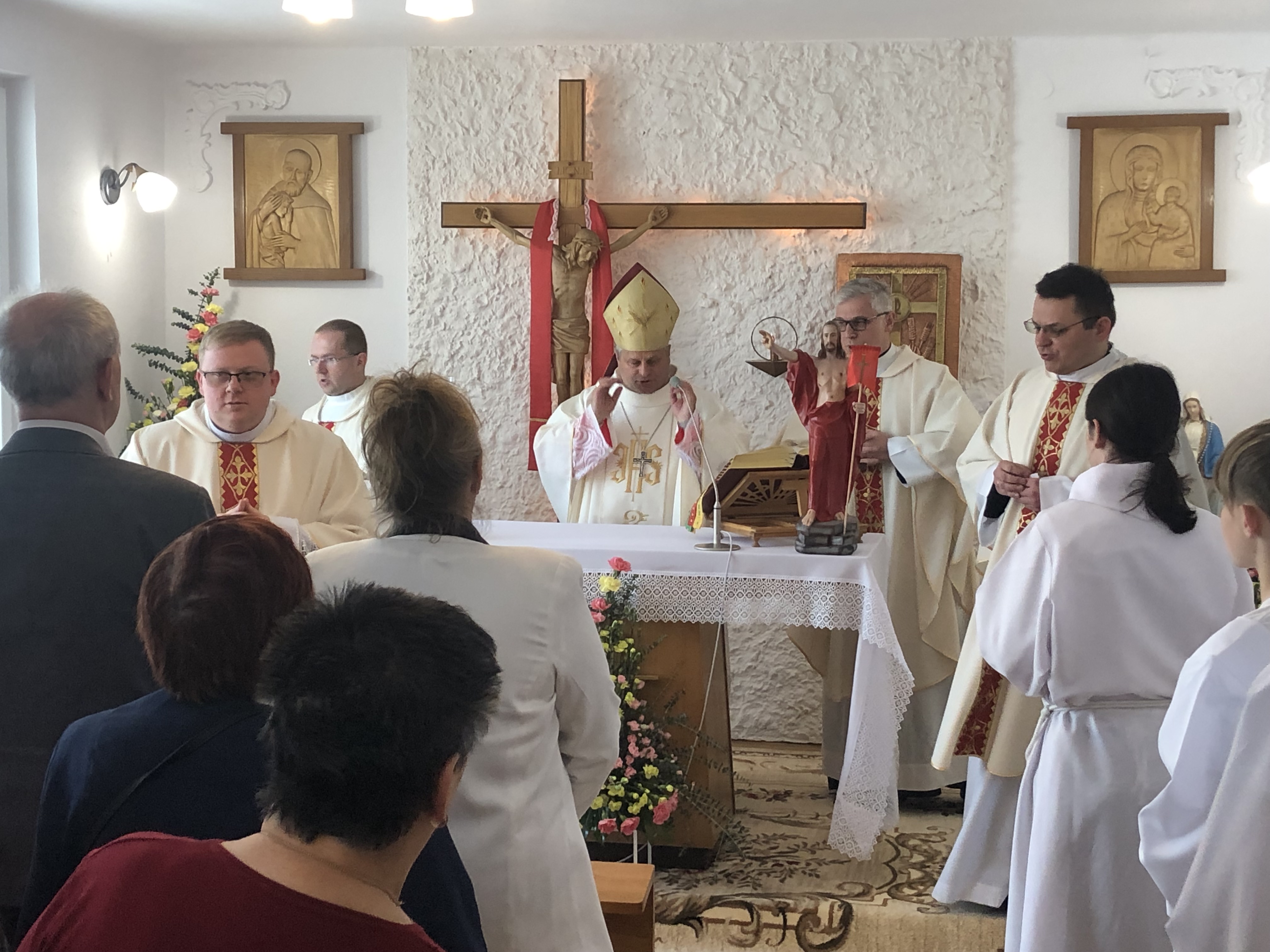 Kadr na uczestników nabożeństwa, siedzących w ławkach, oraz kapelanów przy ołtarzu