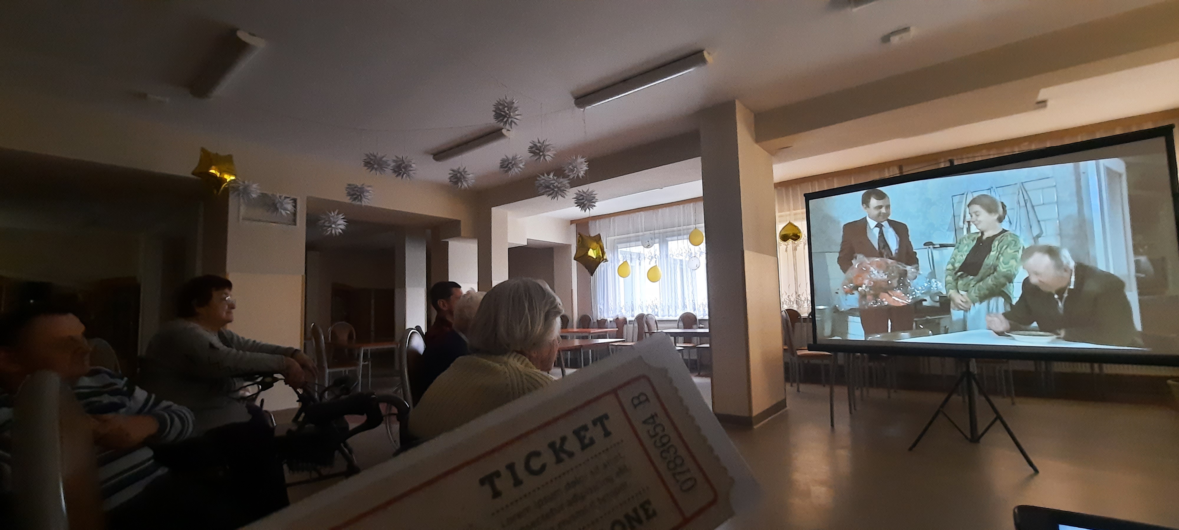 Seniorzy oglądają film na świetlicy