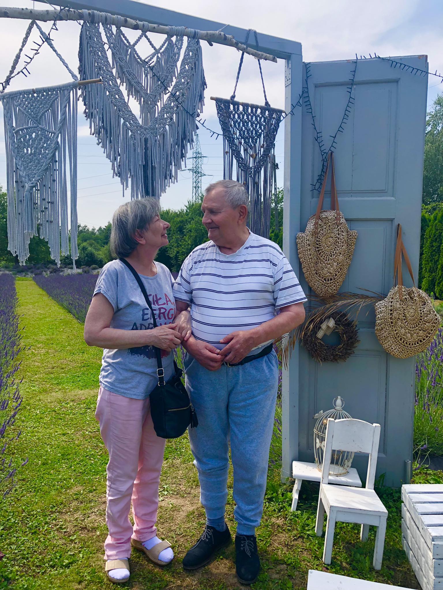 Seniorka oraz Senior pozują do zdjęcia, w tle pole lawendy