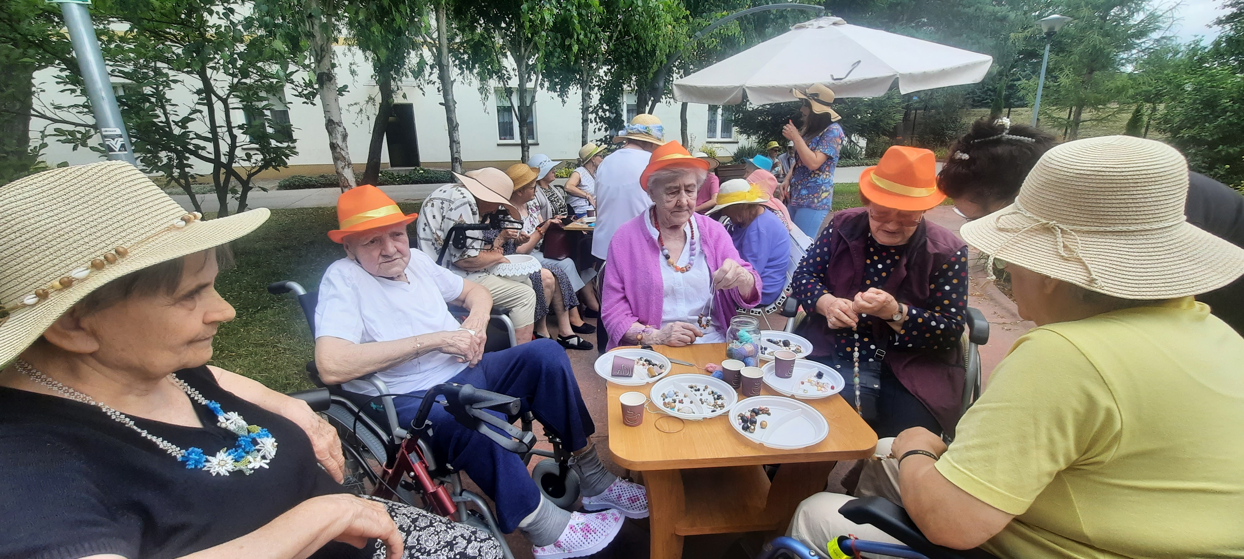 Seniorzy siedzą na świetlicy przy stole