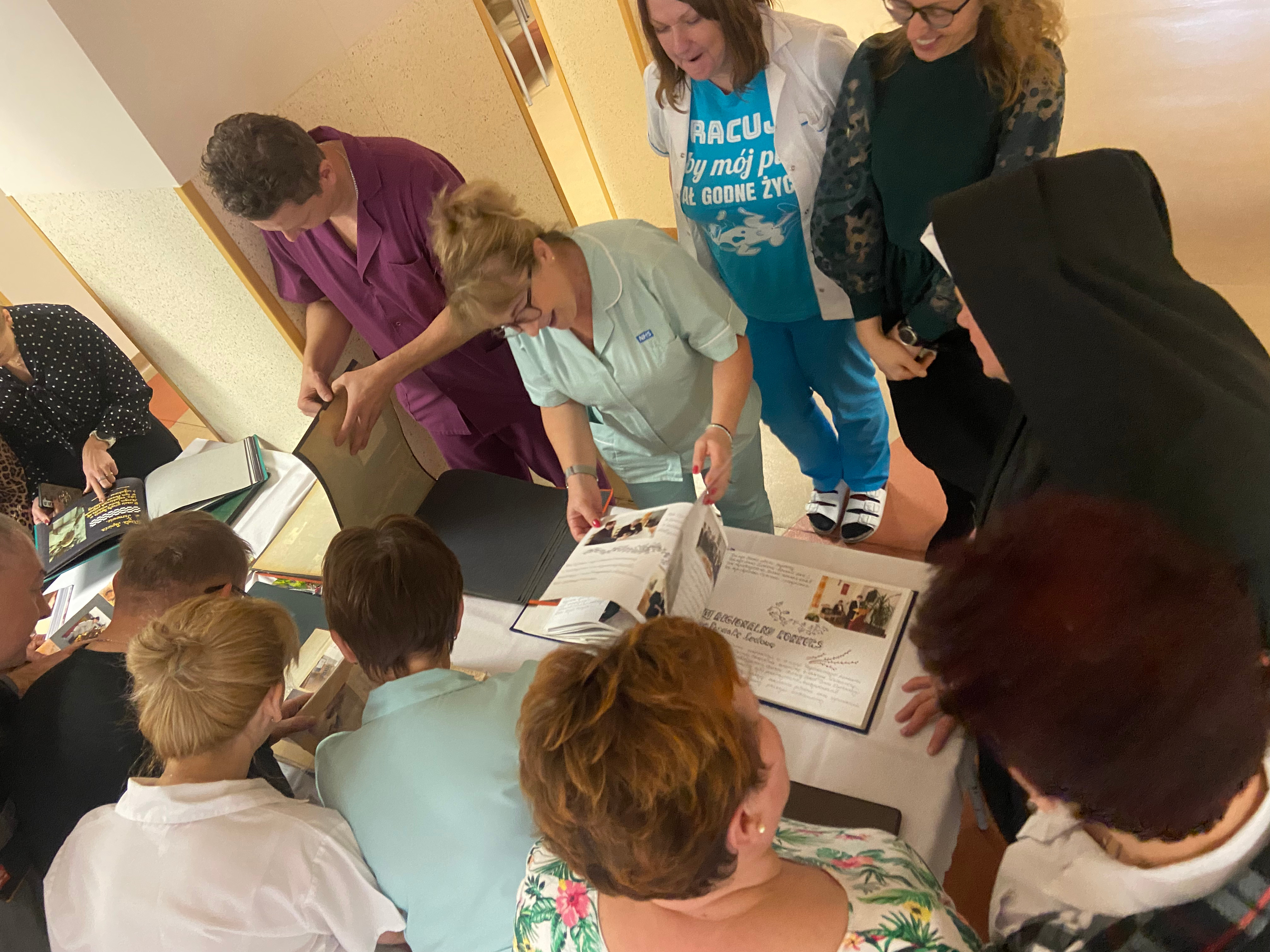 Pracownicy Domu przeglądają wspólnie kroniki Domu