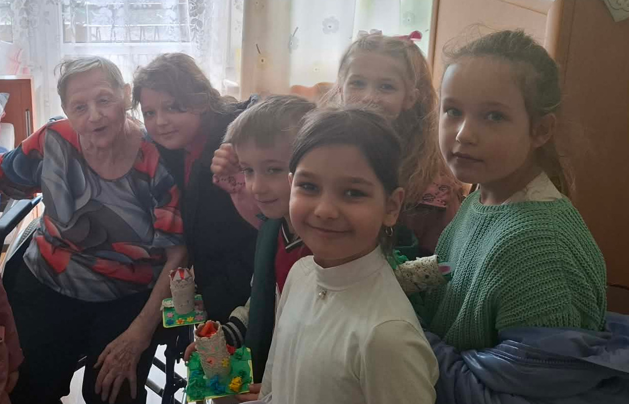 Seniorki pozują do zdjęcia z dziewczynkami w wieku szkolnym