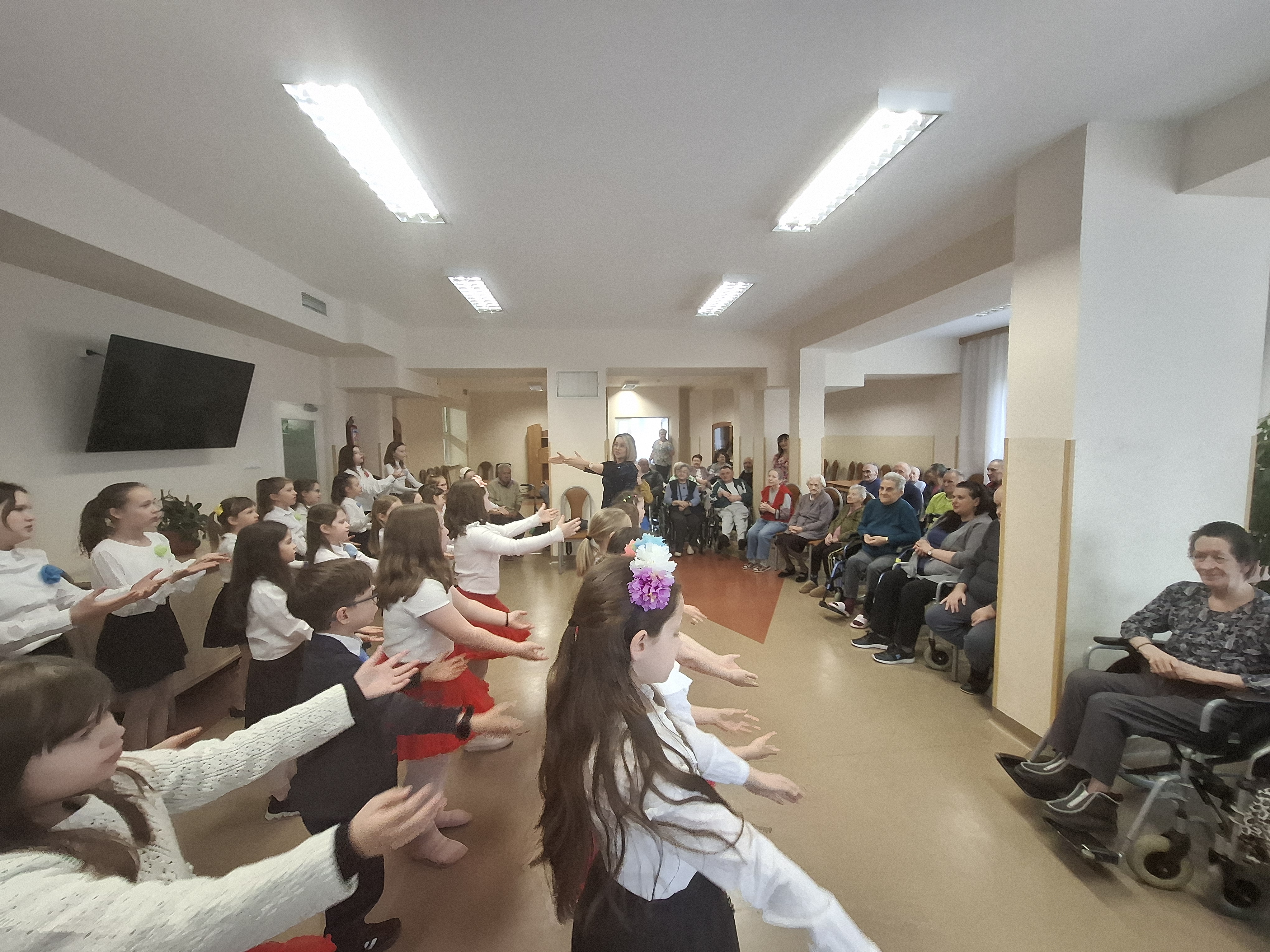 Dzieci ze szkoły podstawowej występują przed Seniorami, wykonując układ taneczny